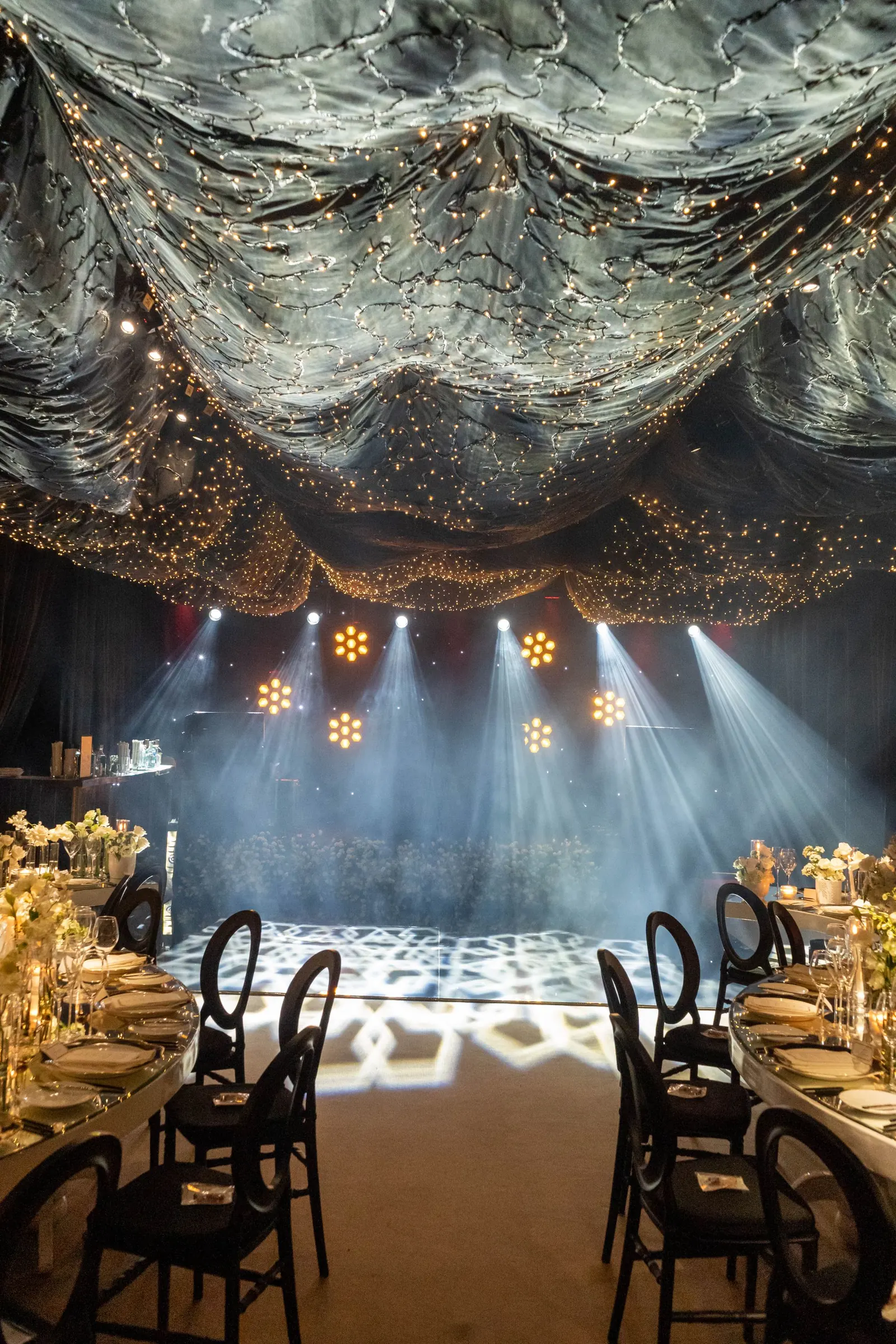 Formal event venue with dramatic lighting and an illuminated dance floor